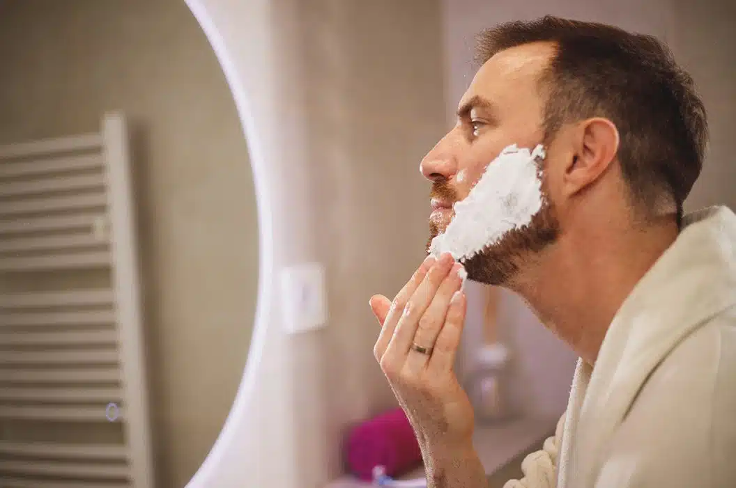 man shaving his face for his photo shoot with shaving cream