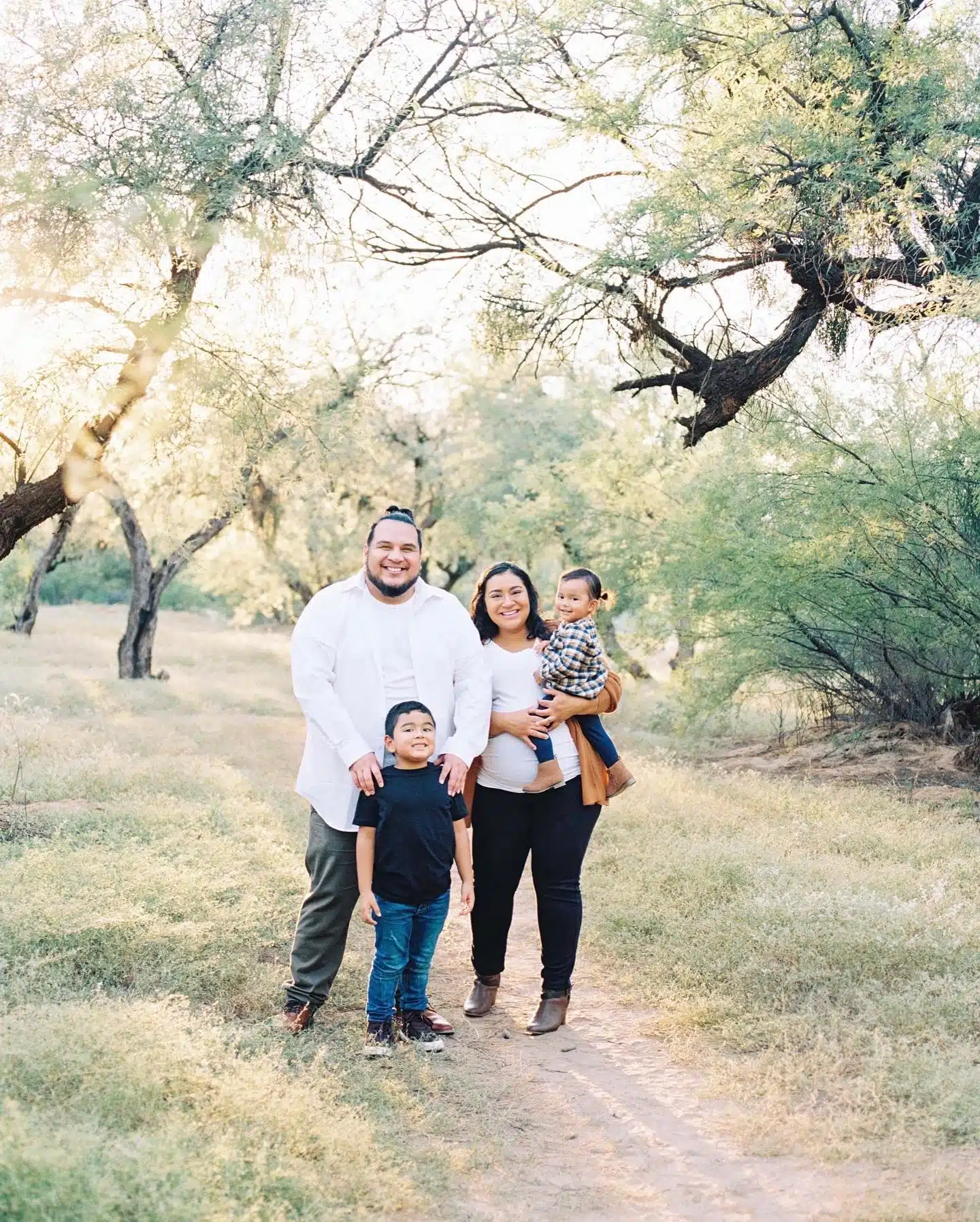 family wearing white shirt, tan beige cardigan, blue jeans, black jeans in greenery in arizona