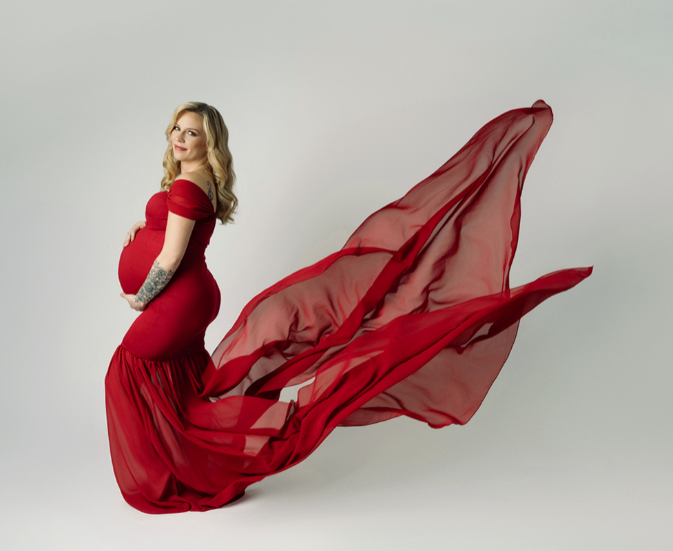 Pregnant woman in a red chiffon dress.