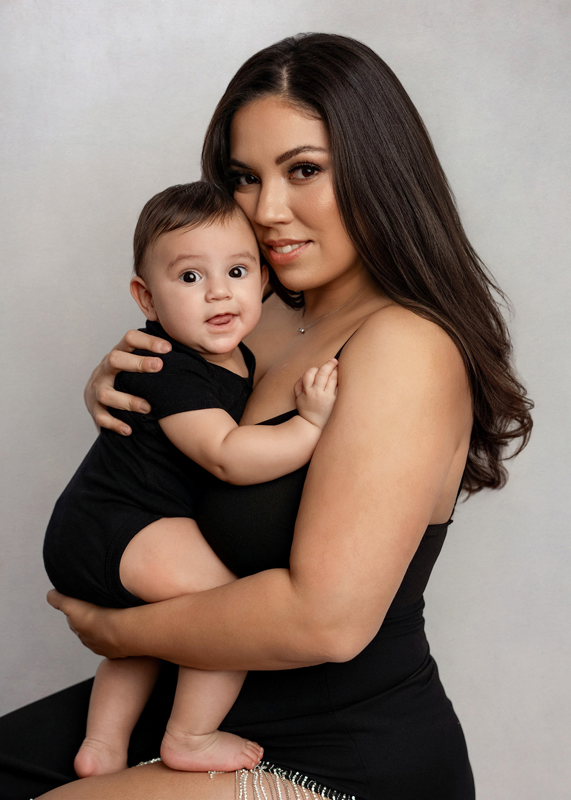 mom holding her baby looking at the camera