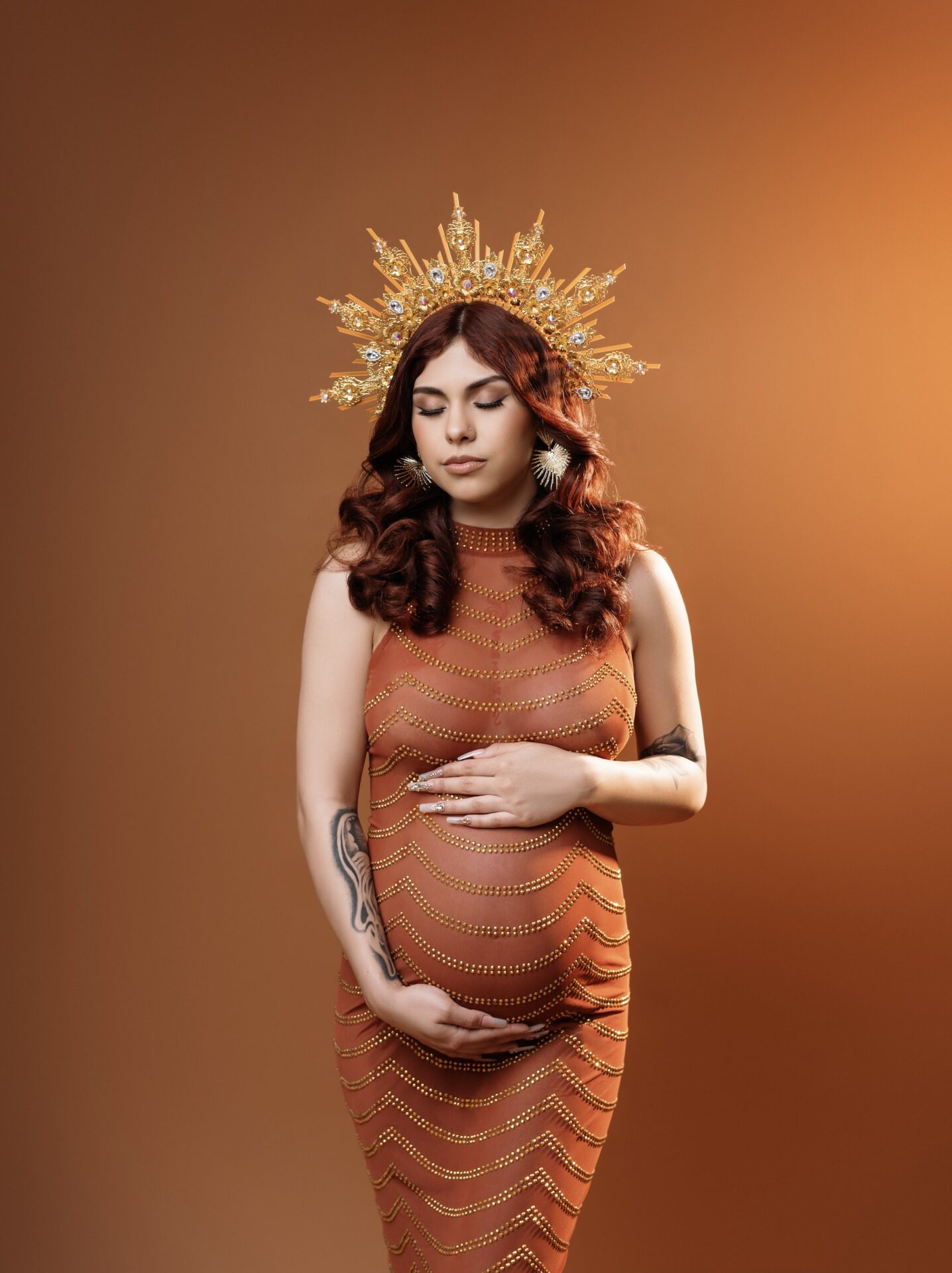 pregnant women in photoshoot with crown and gold wearing diamond dress