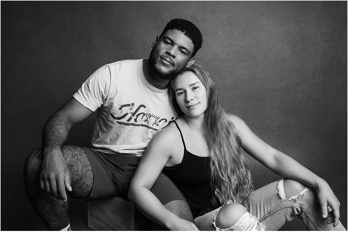 Couples studio portrait in Phoenix with bold shadows and a flirty pose, showing off their chemistry.