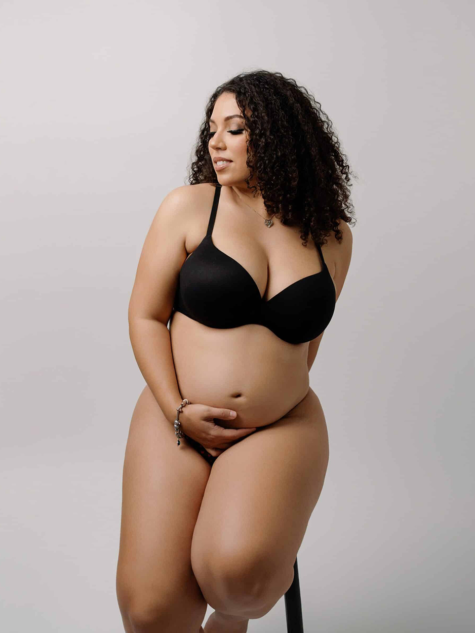 pregnant woman posing for camera in underwear for her maternity session
