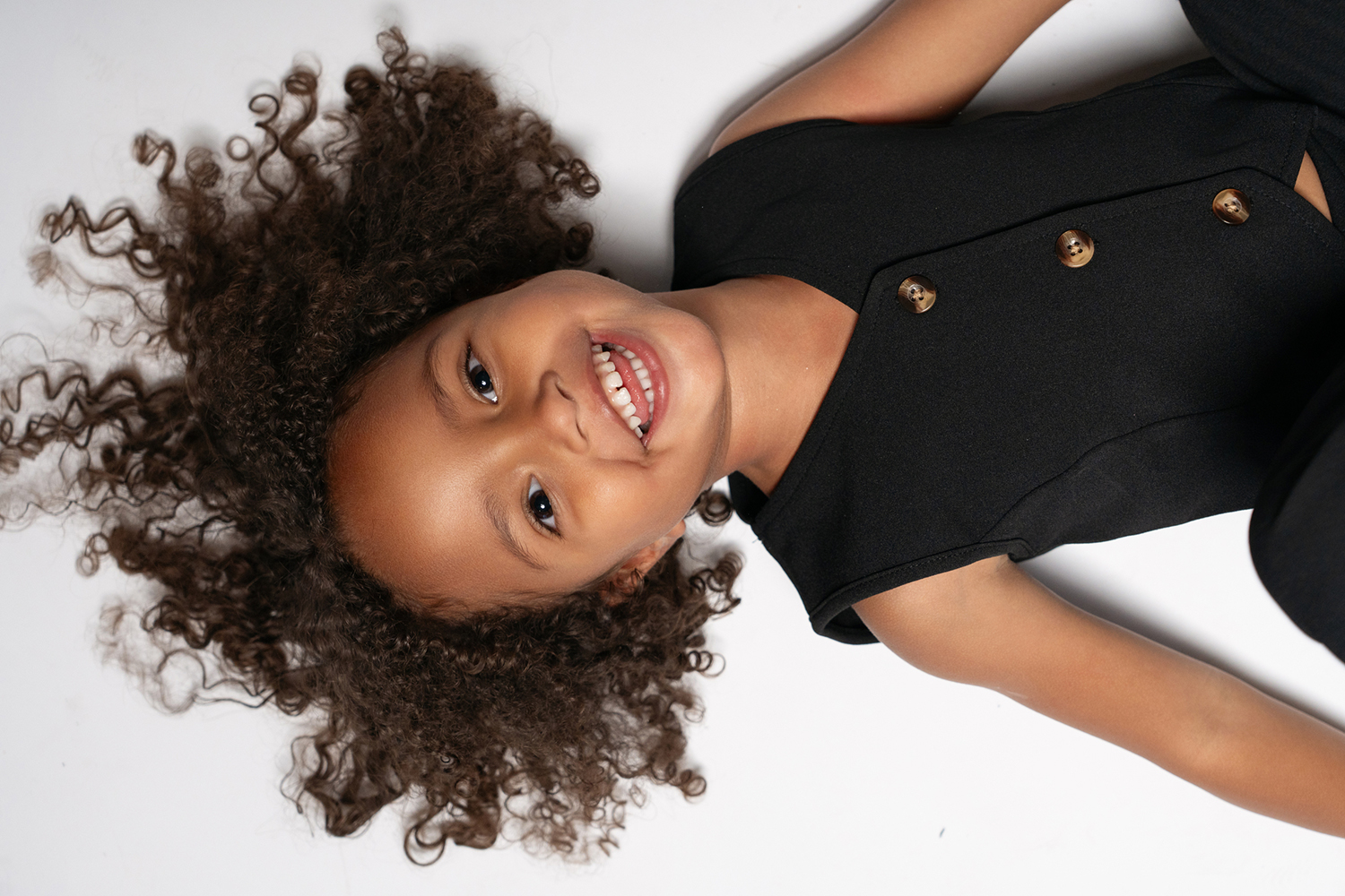 child laughing at the camera upside down for a commercial family photo