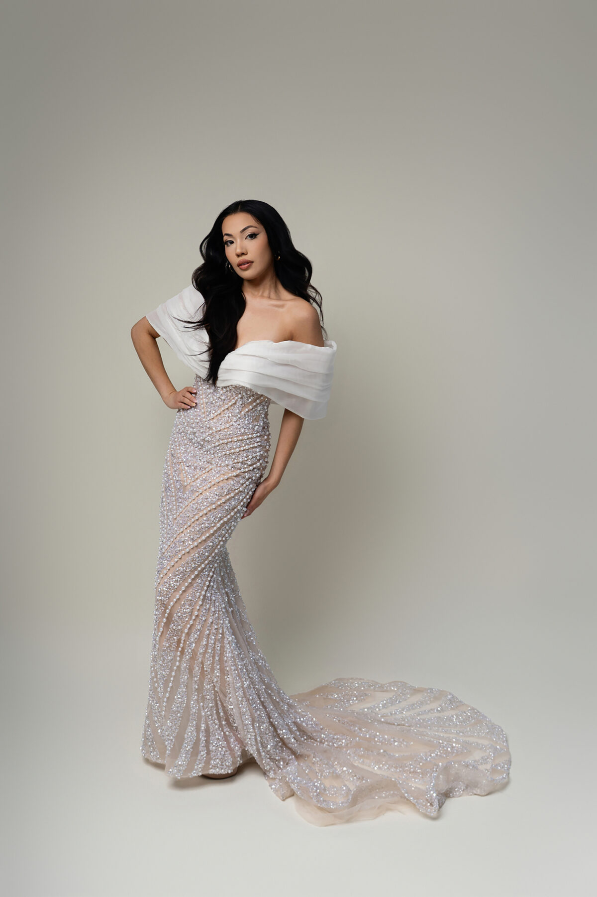 Full-length pageant portrait of Miss Arizona contestant in off-the-shoulder pearl dress with train, posed confidently against light background