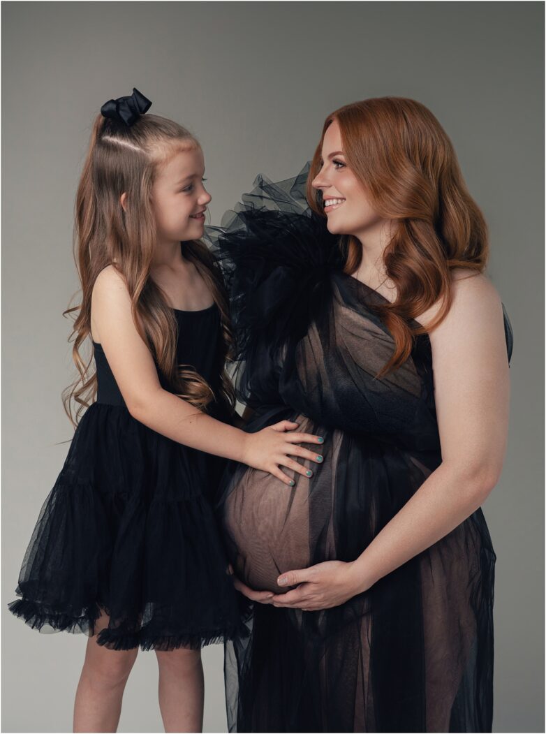 Mother and daughter smiling at each other during a phoenix maternity photography session